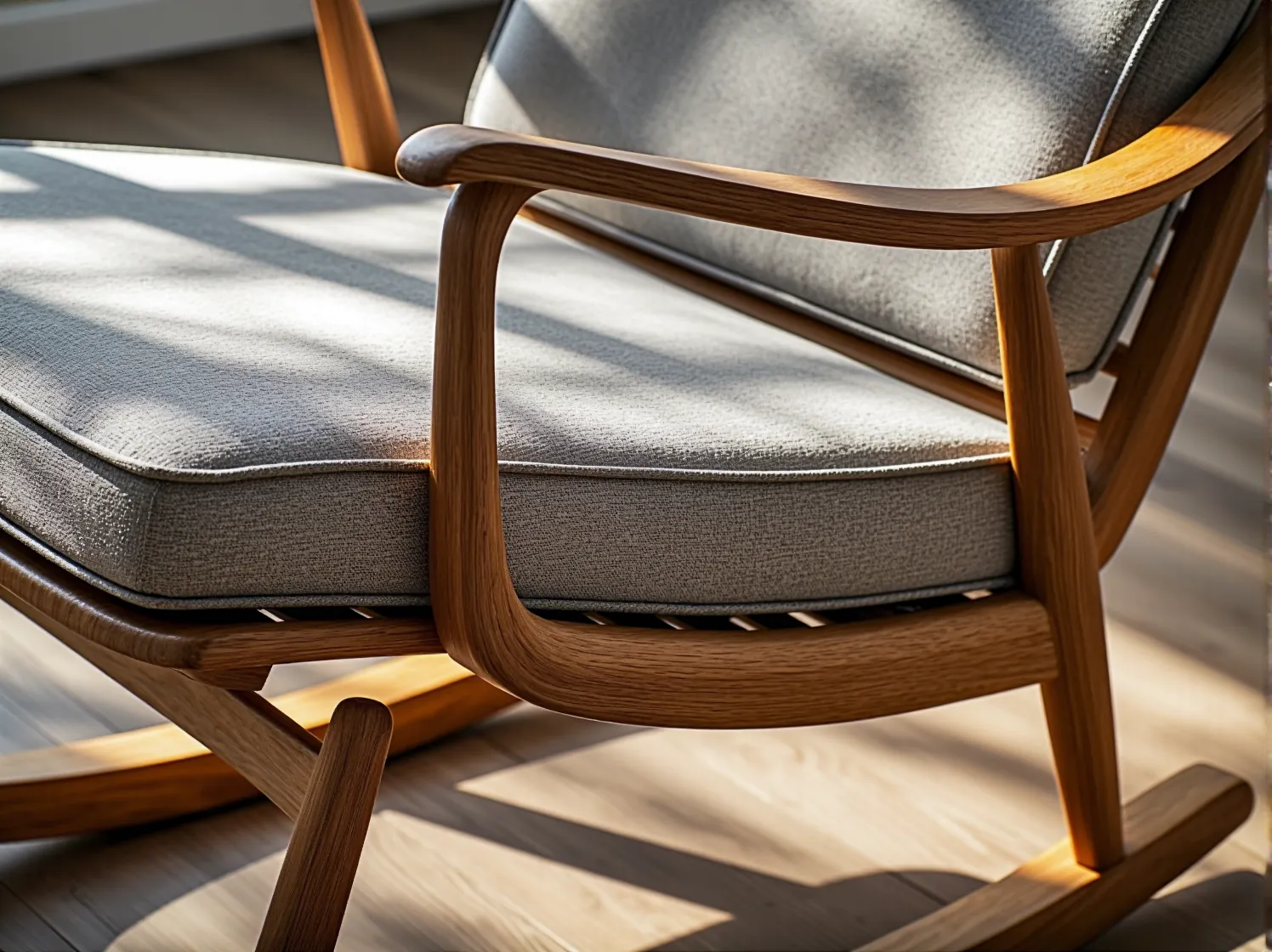 Nowoczesny, szary fotel bujany na drewnianych płozach. Komfort i skandynawski design w jednym.